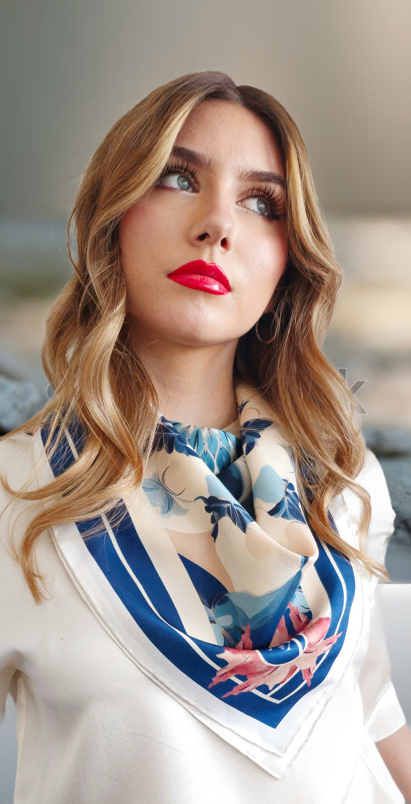 model in white wearing Mazonkiki blue and white silk scarf over neck.