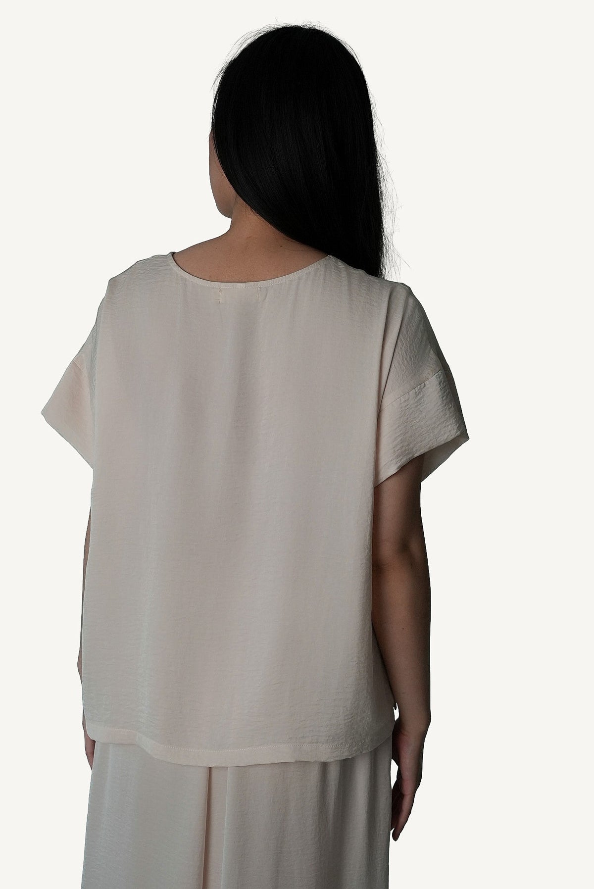Pale Repose Mazonkiki lounge set — ivory wide-leg trouser pools at floor beside a relaxed draped crop top